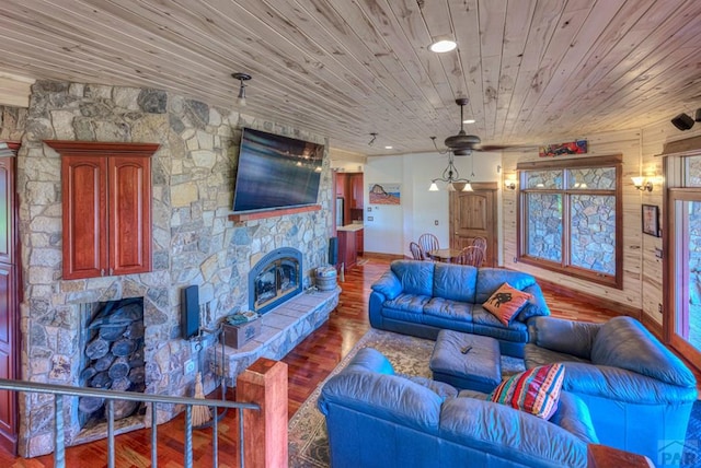 living room with wood ceiling, wood finished floors, and a stone fireplace