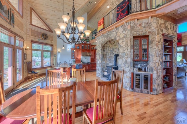 dining area featuring beverage cooler, high vaulted ceiling, wooden ceiling, and light wood-style floors