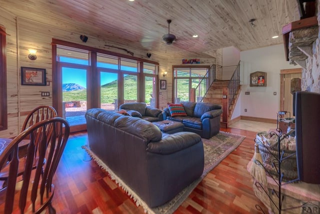 living room with ceiling fan, wooden ceiling, a mountain view, wood finished floors, and stairs