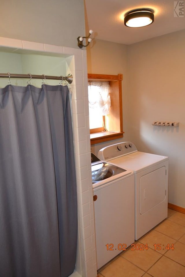 laundry room with laundry area, washing machine and dryer, and light tile patterned flooring