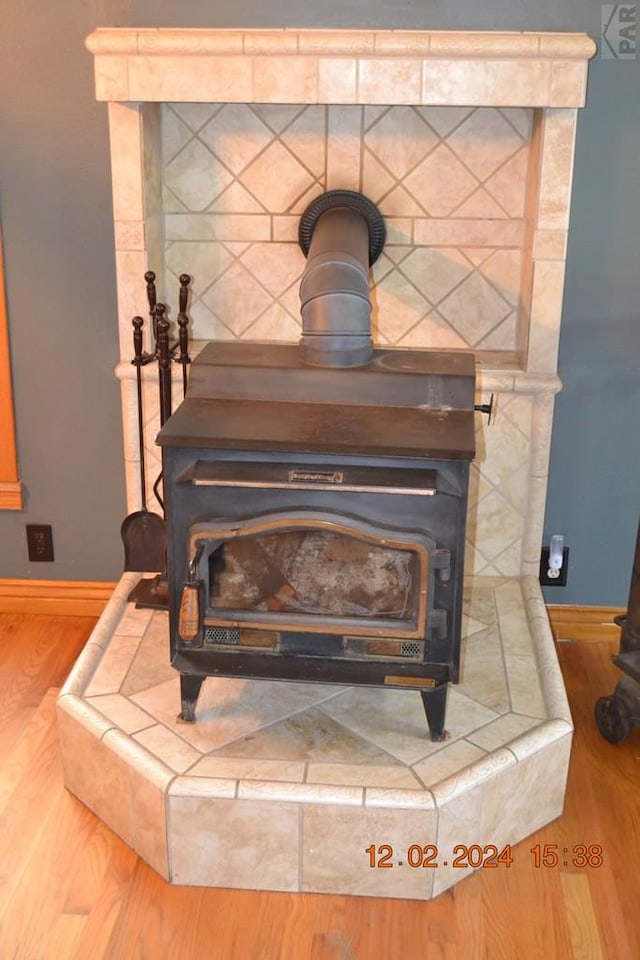 room details featuring a wood stove, baseboards, and wood finished floors