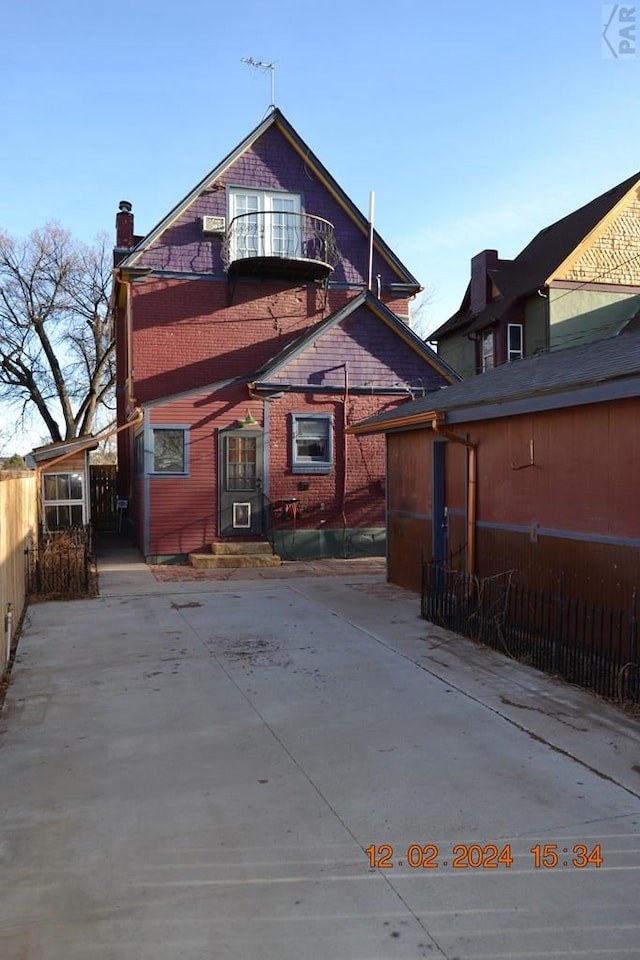 back of property with a chimney and fence