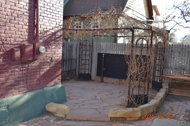 view of gate with a patio area and fence