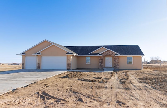 single story home with an attached garage, stone siding, concrete driveway, and stucco siding