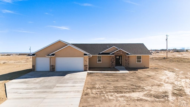 view of front of property featuring stone siding, driveway, an attached garage, and stucco siding