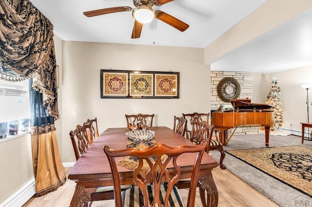 dining area featuring baseboards, light wood-type flooring, and ceiling fan