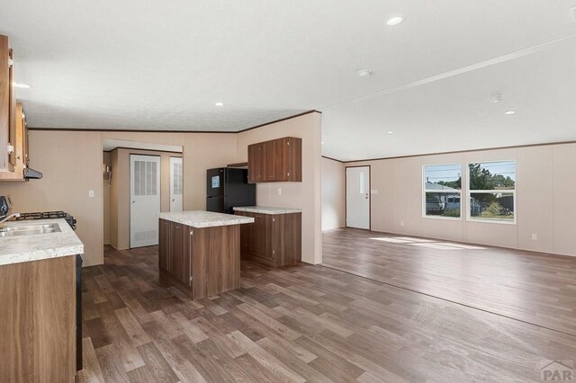 kitchen featuring light countertops, wood finished floors, freestanding refrigerator, and a center island