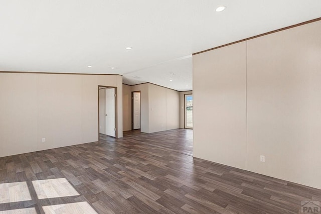 empty room with recessed lighting, crown molding, and wood finished floors