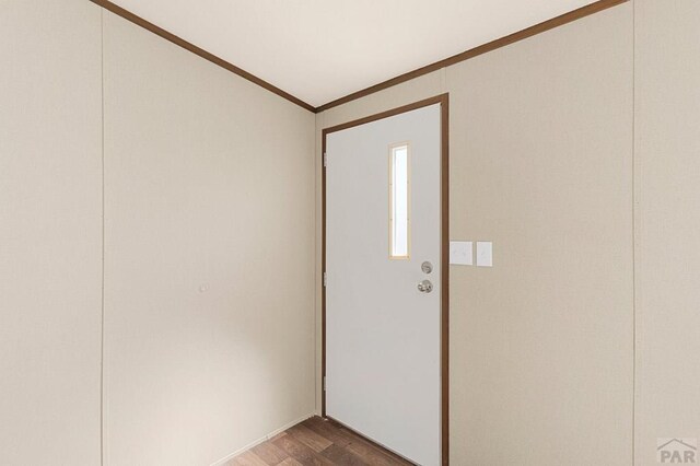 foyer entrance featuring dark wood-style floors and ornamental molding