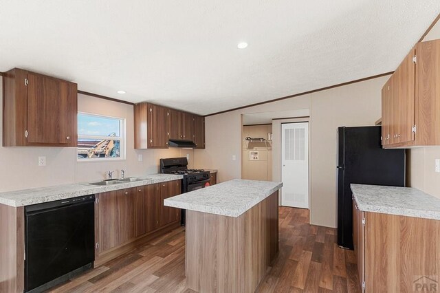 kitchen featuring a sink, under cabinet range hood, light countertops, black appliances, and dark wood-style flooring