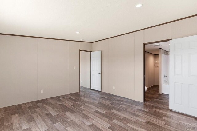 spare room with crown molding and wood finished floors