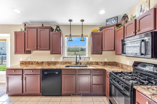 kitchen with light stone countertops, plenty of natural light, a sink, and black appliances