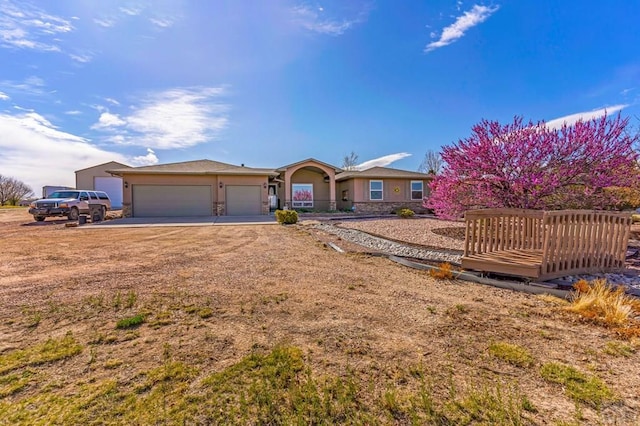 single story home featuring an attached garage, driveway, and stucco siding