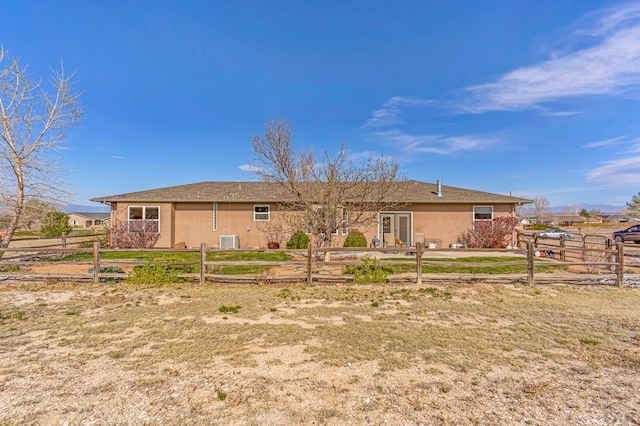 back of property featuring fence and stucco siding