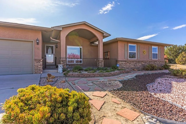 view of front of property with covered porch, an attached garage, stone siding, and stucco siding