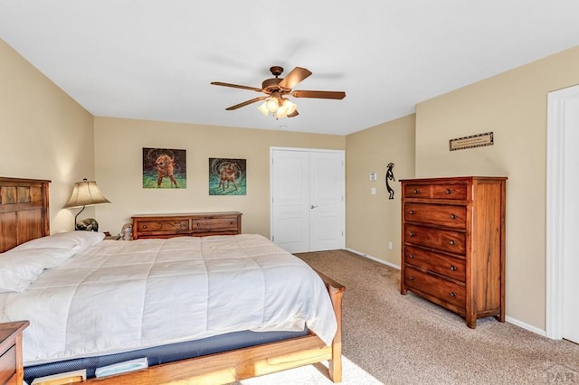 bedroom featuring a ceiling fan, baseboards, a closet, and carpet