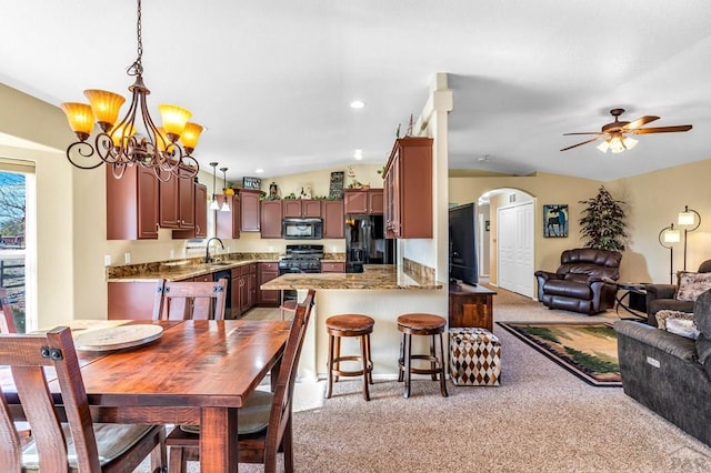 dining room with light colored carpet, arched walkways, recessed lighting, and ceiling fan with notable chandelier