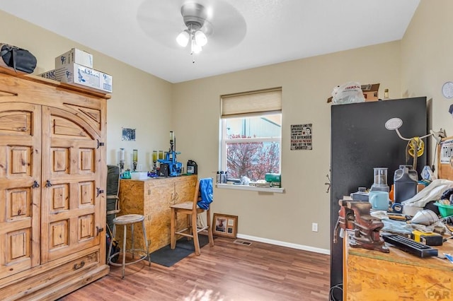 interior space with visible vents, baseboards, a ceiling fan, and wood finished floors