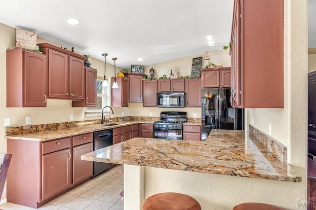 kitchen featuring a sink, light stone countertops, pendant lighting, black appliances, and a peninsula