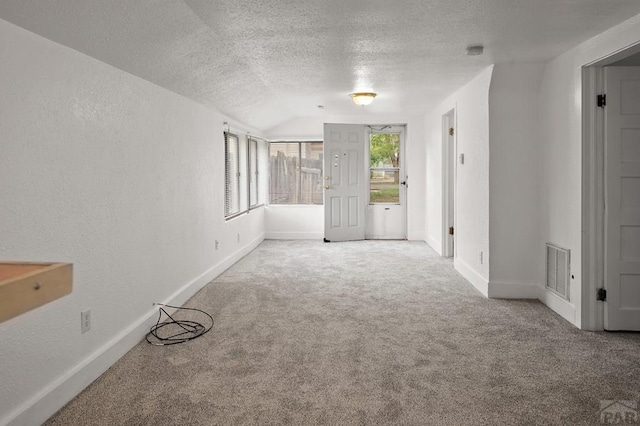1638 Jackson St, Pueblo, CO 81004 - empty room with carpet, a textured ceiling, vaulted ceiling, and baseboards