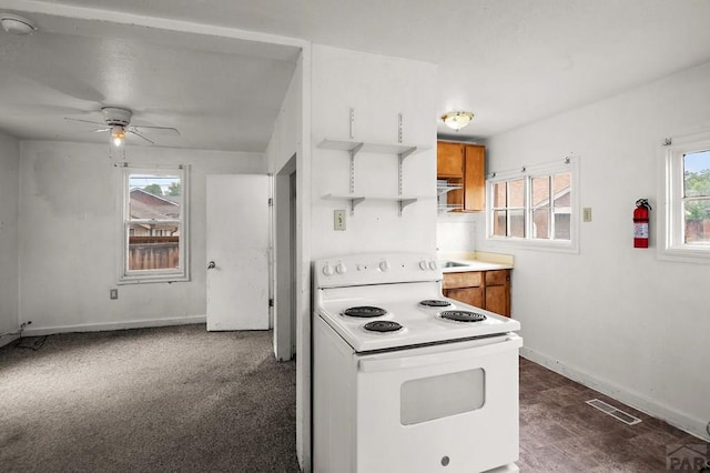 1638 Jackson St, Pueblo, CO 81004 - kitchen with white electric stove, healthy amount of natural light, ceiling fan, and baseboards