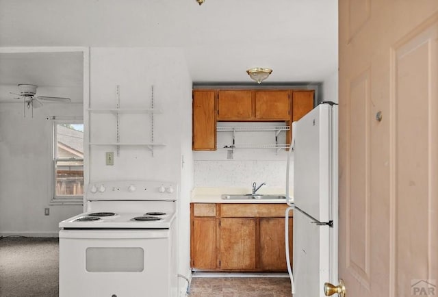 1638 Jackson St, Pueblo, CO 81004 - kitchen featuring white appliances, brown cabinets, a sink, ceiling fan, and light countertops
