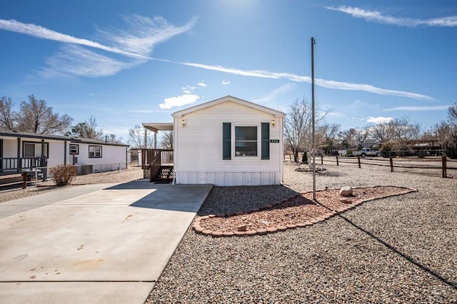 view of front of property featuring driveway and fence