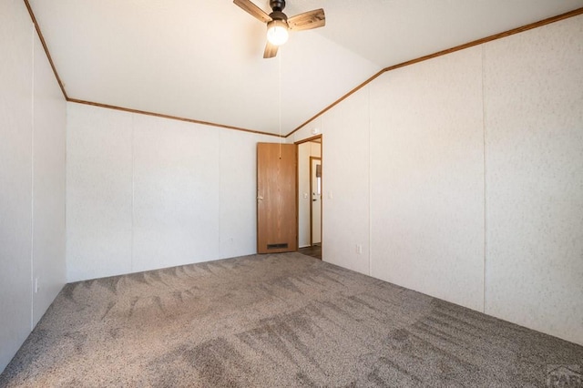 spare room with vaulted ceiling, ornamental molding, carpet flooring, and a ceiling fan