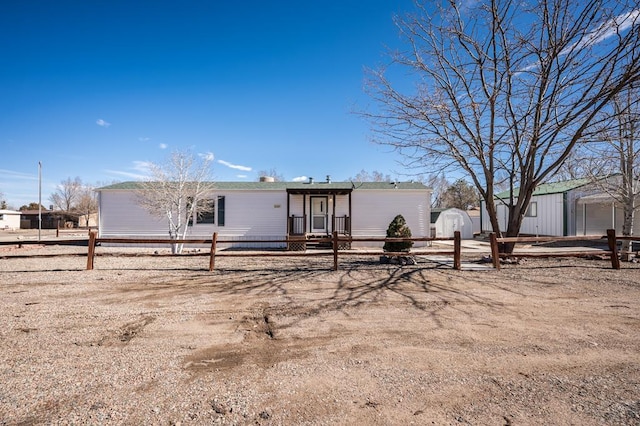 view of front of home featuring an outbuilding, a shed, and a fenced front yard