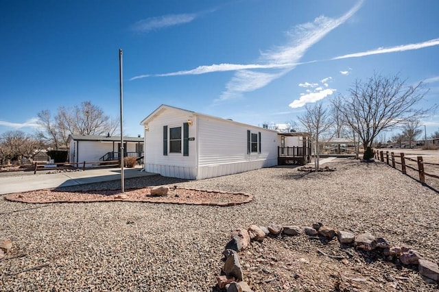 view of side of property with an outbuilding and fence