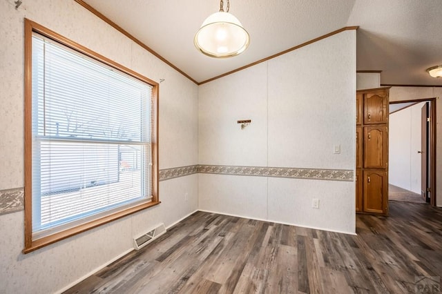 spare room featuring ornamental molding, dark wood-type flooring, and visible vents