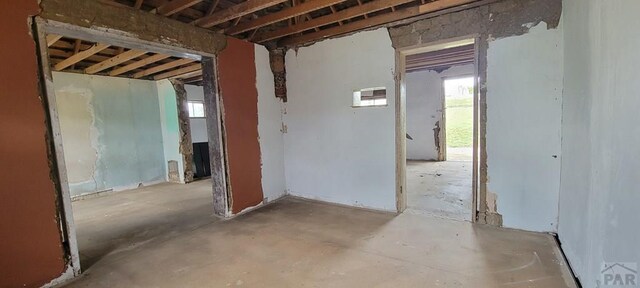 misc room with plenty of natural light and unfinished concrete floors