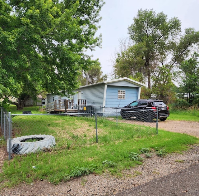 exterior space featuring fence, driveway, and a wooden deck