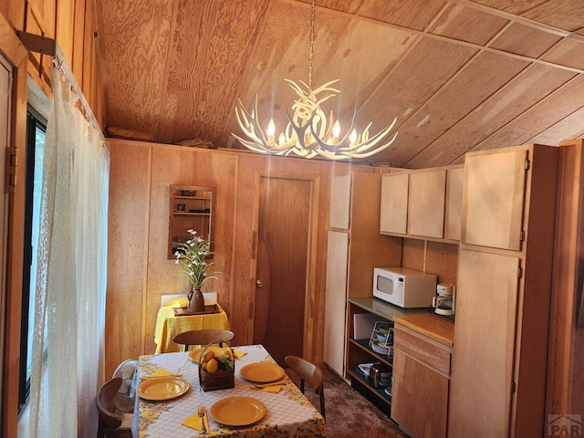 kitchen featuring wooden ceiling, white microwave, decorative light fixtures, wood walls, and a chandelier