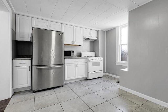 1111 Topaz Pl, Pueblo, CO 81004 - kitchen with light tile patterned flooring, under cabinet range hood, stainless steel appliances, and white cabinetry
