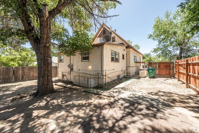 rear view of house featuring a fenced backyard