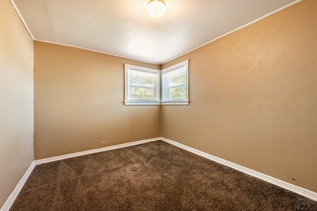 carpeted empty room featuring baseboards