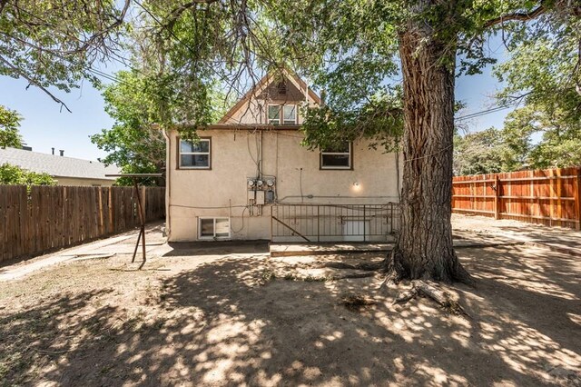 rear view of house with a fenced backyard