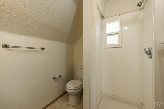 bathroom featuring vaulted ceiling and toilet