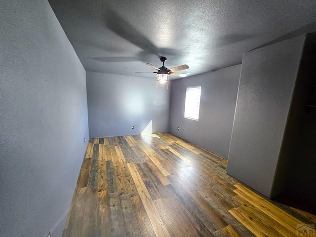 spare room featuring a ceiling fan, a textured ceiling, and wood finished floors