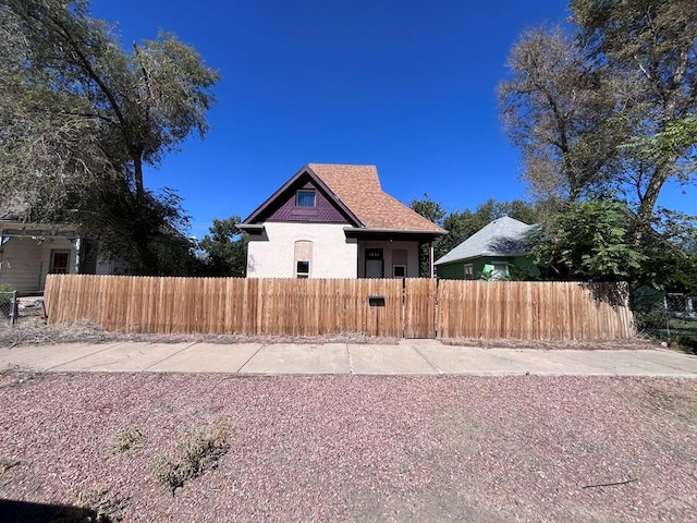 view of property exterior with a fenced front yard and roof with shingles