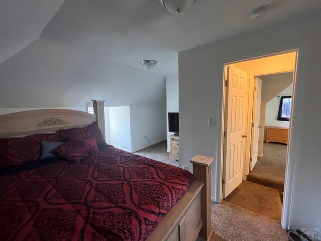 bedroom with light carpet and lofted ceiling