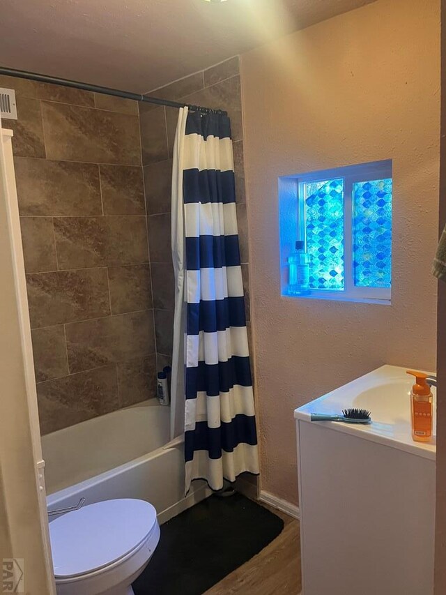 full bathroom with wood finished floors, vanity, toilet, and shower / bath combo with shower curtain