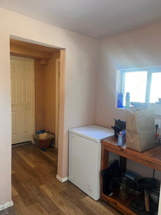 clothes washing area with dark wood-style flooring