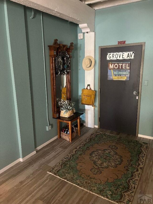 interior space with dark wood-type flooring and baseboards