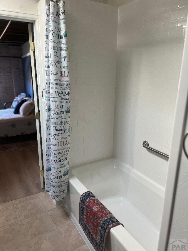 full bathroom featuring connected bathroom, a tub, and tile patterned floors