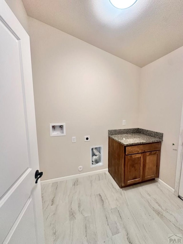 clothes washing area featuring baseboards, cabinet space, electric dryer hookup, washer hookup, and hookup for a gas dryer