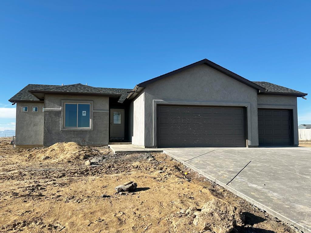 view of front facade featuring a garage, driveway, and stucco siding