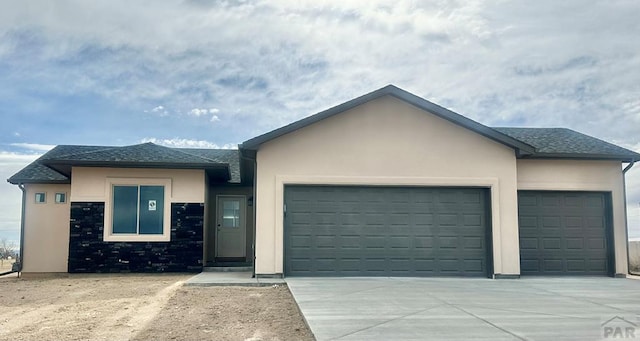 single story home with a garage, driveway, and stucco siding