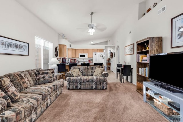 living room with visible vents, light carpet, high vaulted ceiling, a ceiling fan, and arched walkways